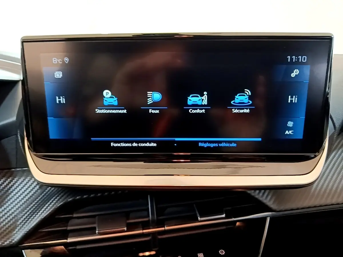 Écran tactile central affichant les réglages de conduite dans l'habitacle d'une Peugeot 208 jaune 2023.