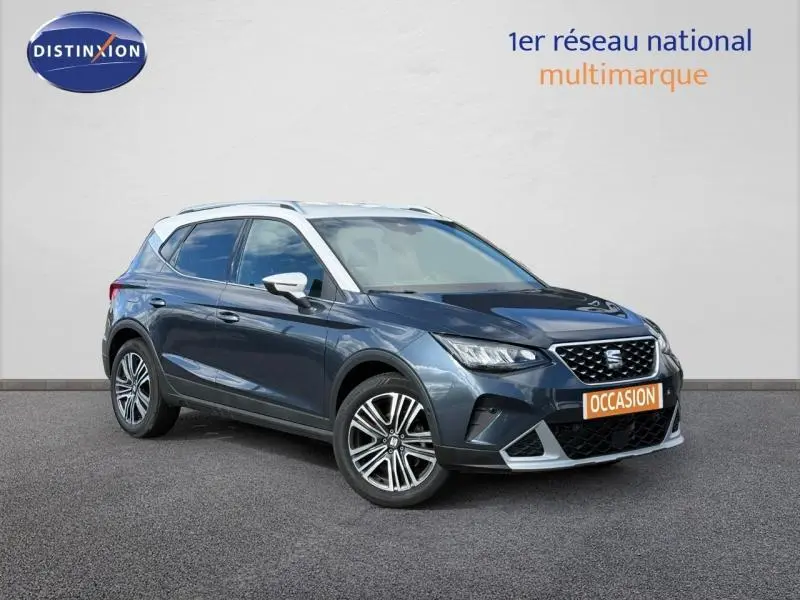 SEAT Arona 2025 bleu saphir métal avec toit blanc, vue 3/4 avant droit mettant en valeur ses jantes et calandre.