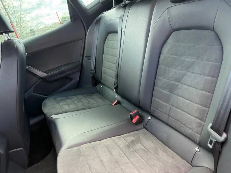 Vue intérieure des sièges arrière en tissu gris et cuir noir du SEAT Arona 2025, côté gauche visible.
