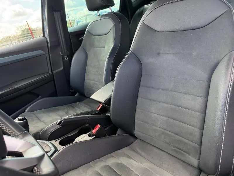 Vue rapprochée des sièges avant en tissu et cuir noir du SEAT Arona 1.0 TSI 115ch Xperience 2025, intérieur sobre et moderne.