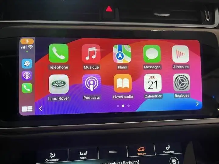 Écran tactile central du Range Rover Evoque noir Santorini, affichant les applications Apple CarPlay en intérieur.