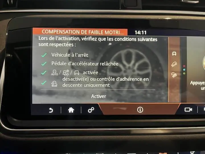 Écran tactile intérieur du Range Rover Evoque affichant les instructions pour la compensation de faible motricité.