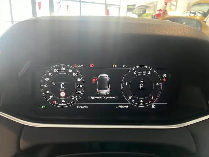 Tableau de bord numérique du Range Rover Evoque noir, affichant vitesse, régime moteur et vue 360° du véhicule.