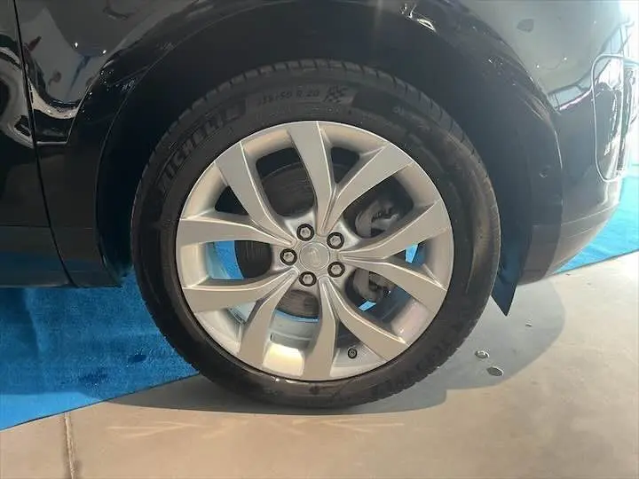 Gros plan sur la roue avant droite du Range Rover Evoque noir Santorini, mettant en valeur la jante alliage et le pneu Michelin.