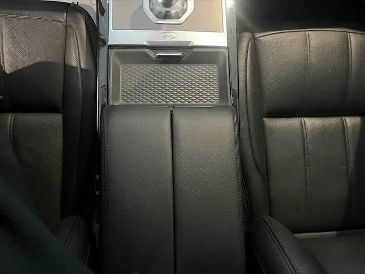 Vue plongeante sur la console centrale et les sièges en cuir noir grainé du Range Rover Evoque II 2020.