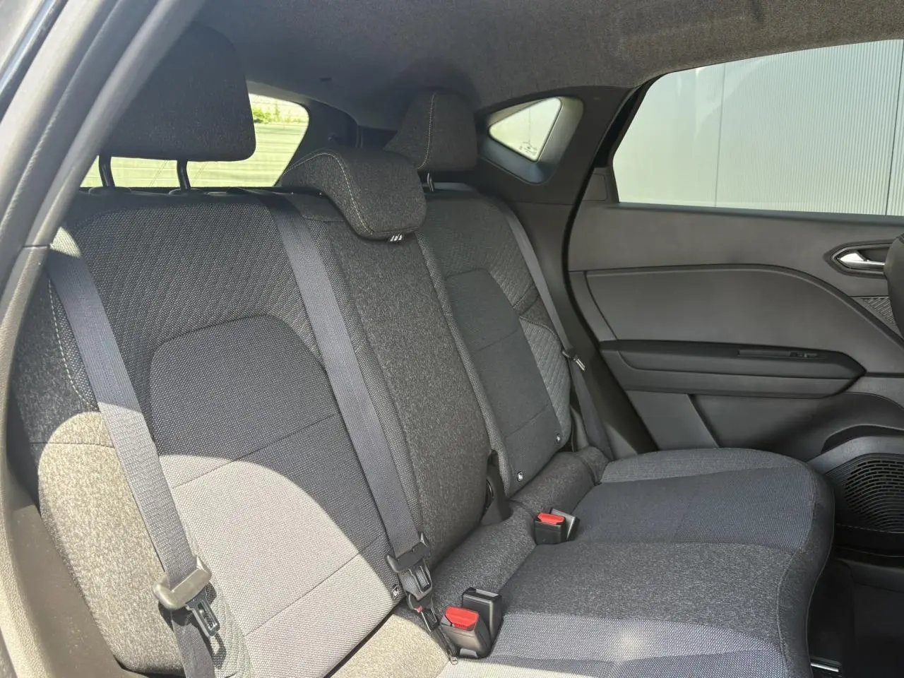 Banquette arrière en tissu gris vue côté droit dans le Renault Captur noir étoile 2025 hybride.
