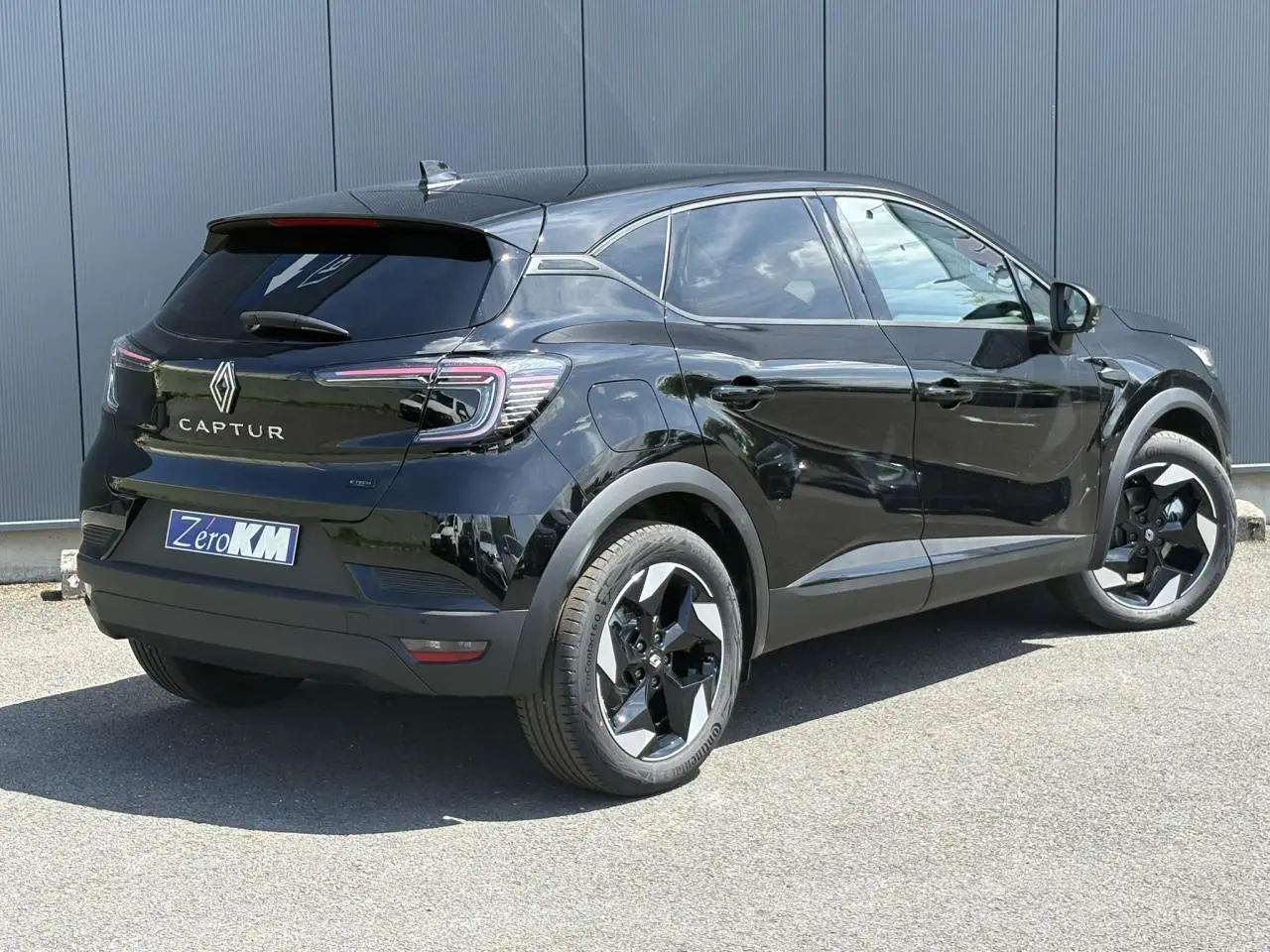 Vue 3/4 arrière droite d'un Renault Captur noir étoile avec jantes aluminium 18 pouces et vitres surteintées.