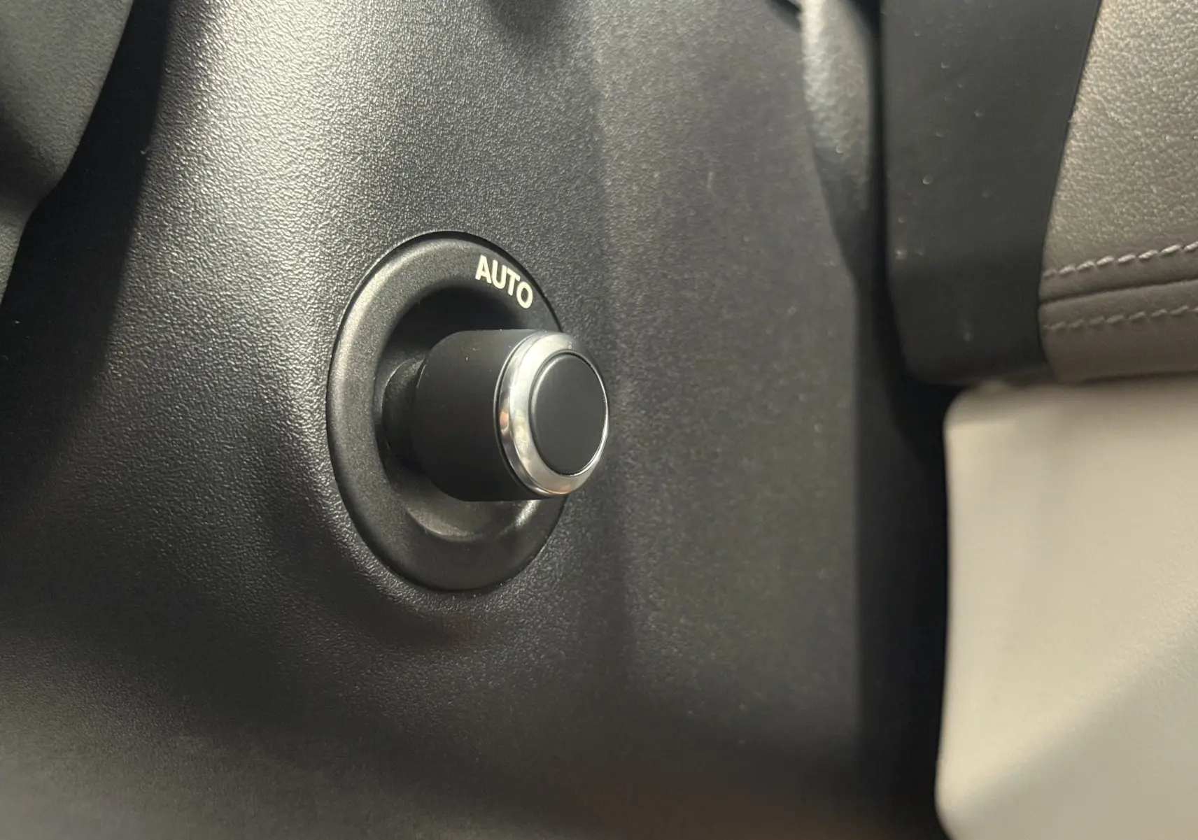 Bouton rotatif "AUTO" en gros plan sur le tableau de bord intérieur beige du Jaguar XE 20d 2015.