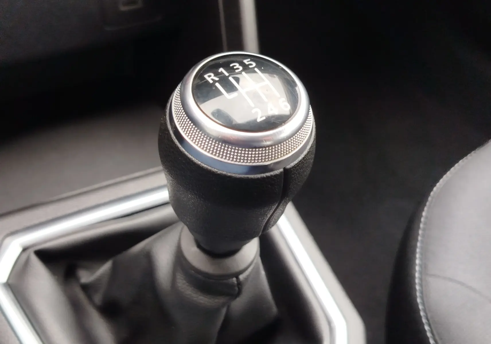 Le levier de vitesses manuel noir de la Dacia Sandero Stepway 2021, vue rapprochée de la commande de boîte à 6 rapports.