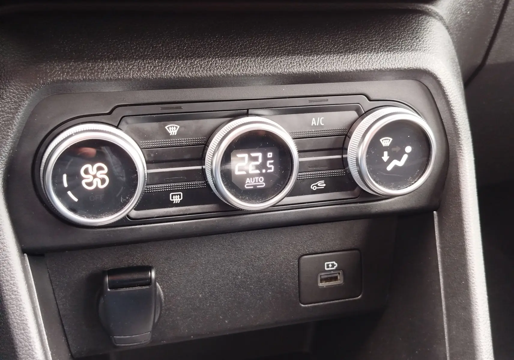 Détail du tableau de bord de la Dacia Sandero Stepway 2021 montrant les commandes de climatisation à 22,5°C et port USB.