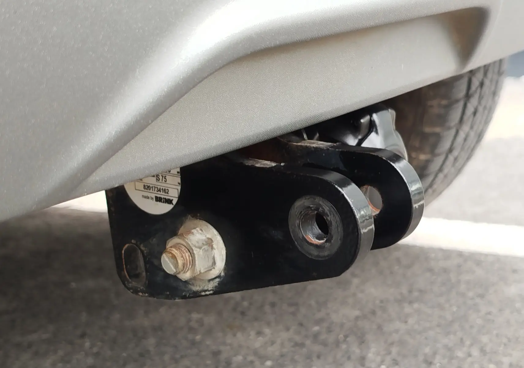 Gros plan sur l'attelage noir fixé sous le pare-chocs blanc glacier arrière d'une Dacia Sandero Stepway 2021.