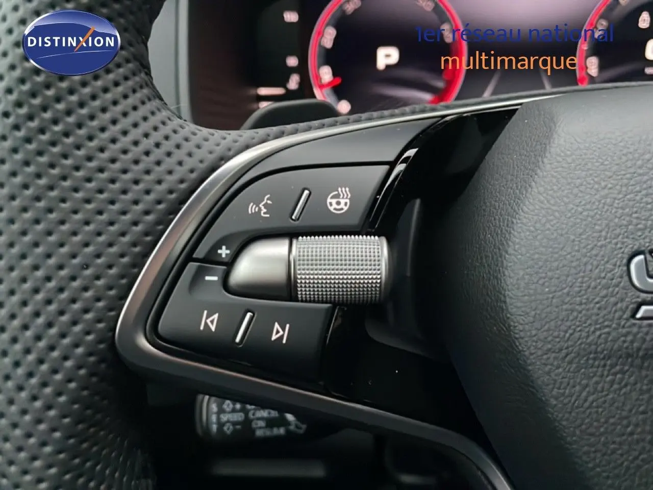 Gros plan sur les commandes au volant en cuir perforé du Skoda Karoq gris argent 2025, avec molette et boutons multifonctions.