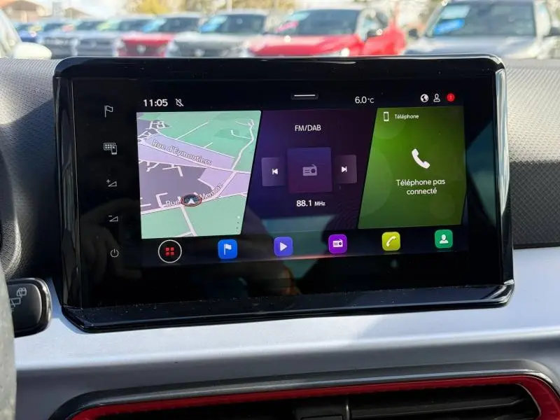 Écran tactile central du tableau de bord du SEAT Arona 2025, affichant navigation, radio et téléphone, intérieur moderne.