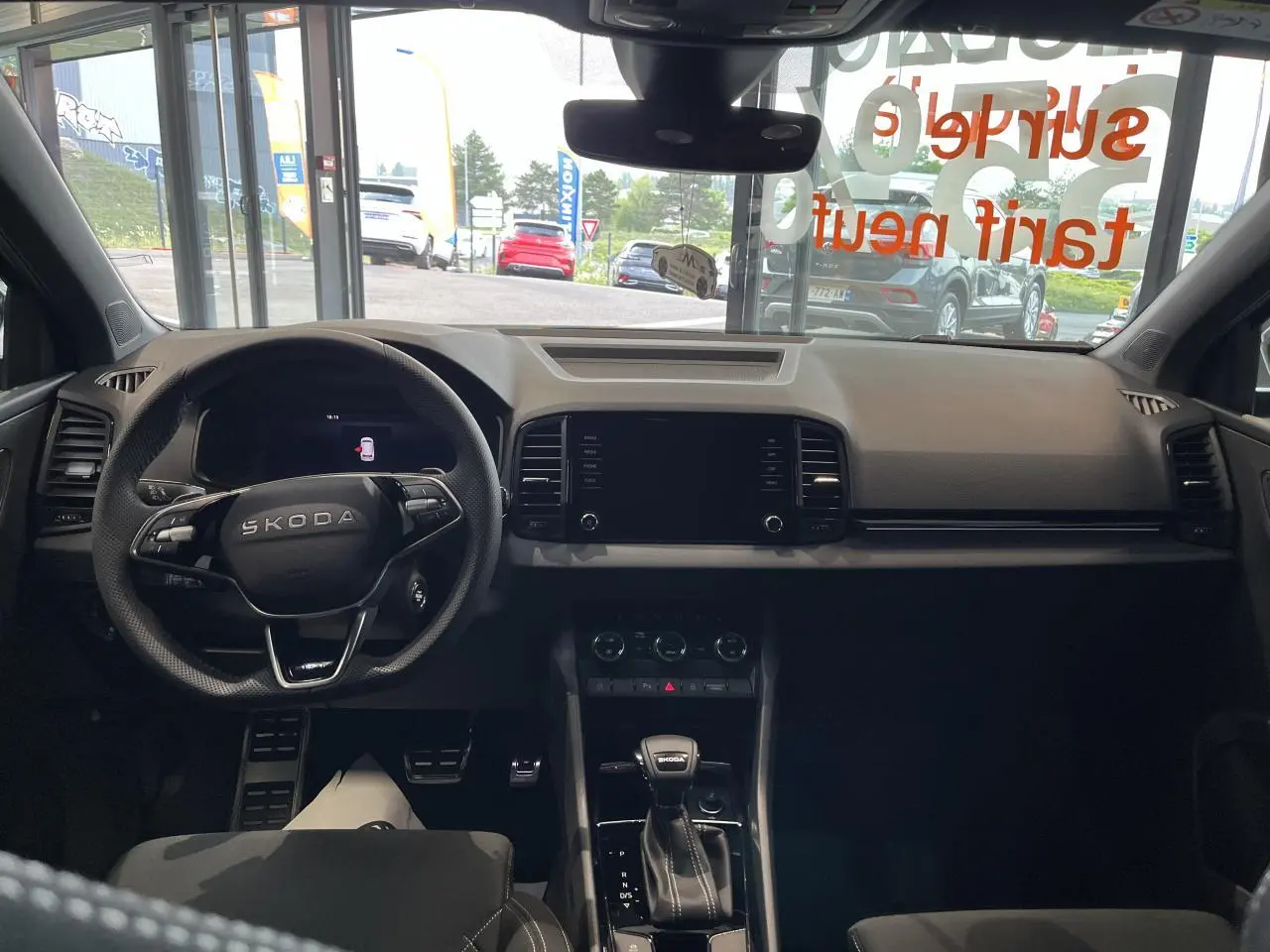 Intérieur du Skoda Karoq 2025 vu de face, tableau de bord noir avec volant sport multifonctions et levier DSG7.