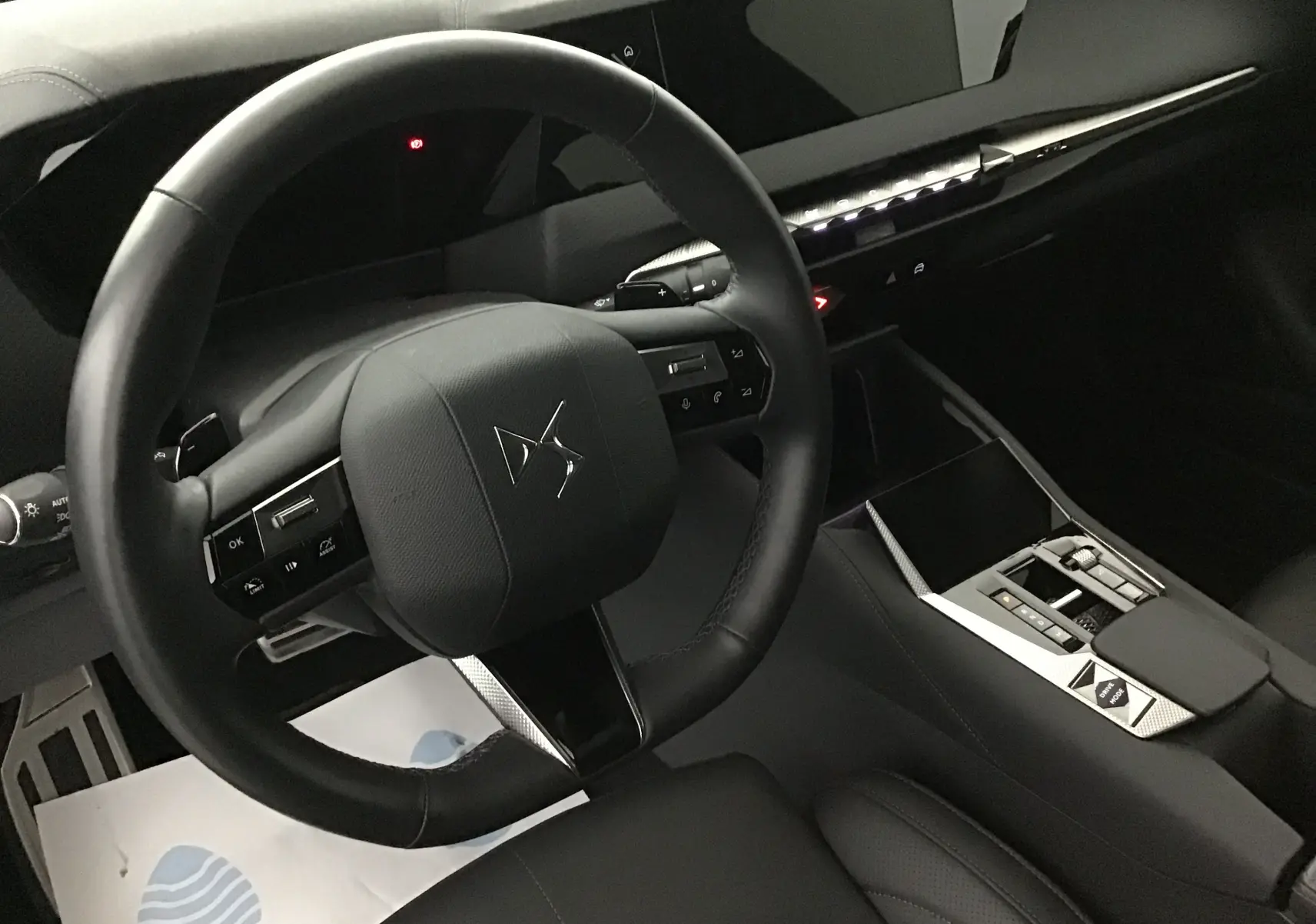 Intérieur noir du DS4 2022 vu côté conducteur, volant compact avec logo DS et console centrale moderne aux finitions soignées.