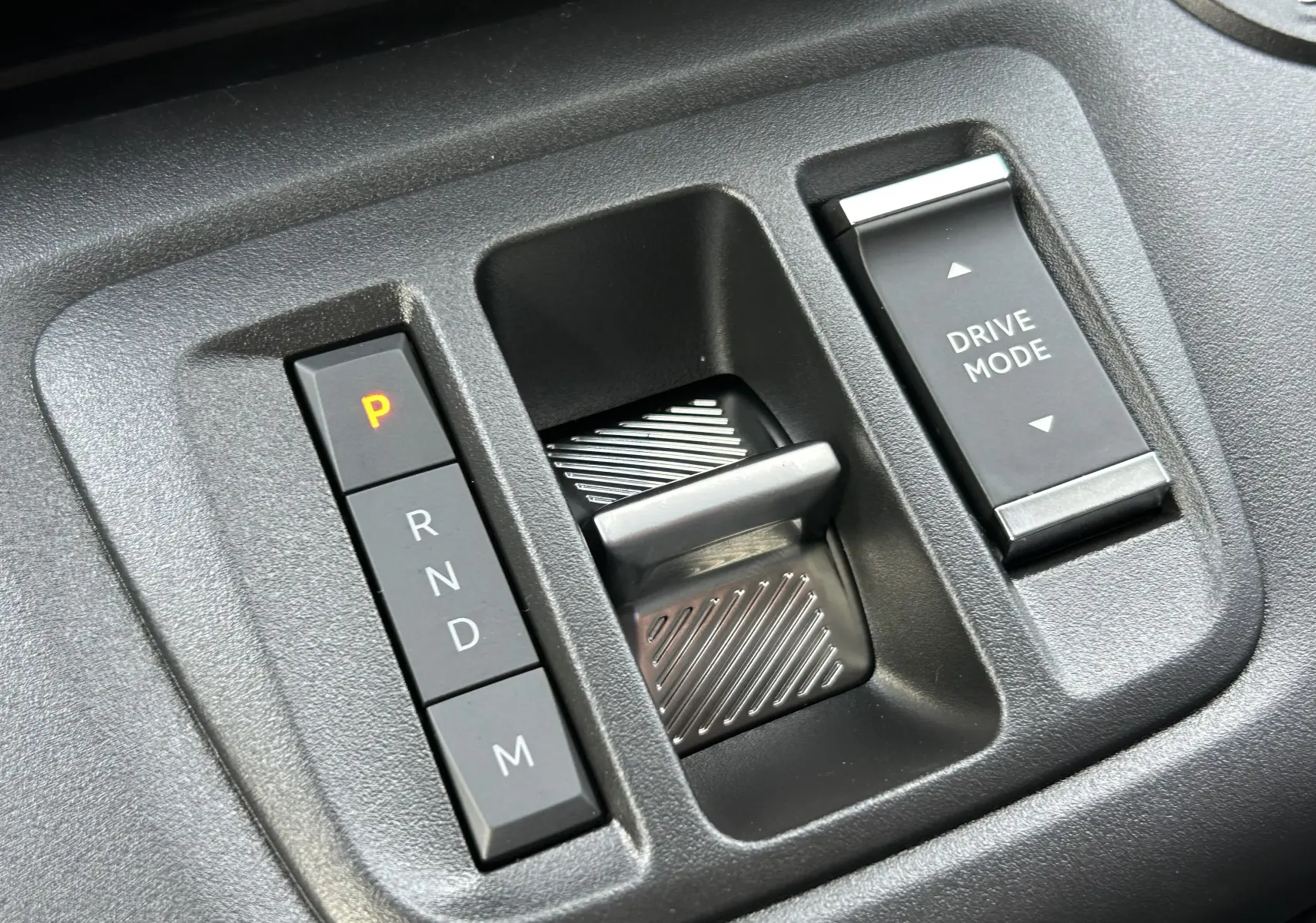 Gros plan sur la commande de boîte automatique et le sélecteur de mode de conduite du Peugeot Partner Fourgon blanc.