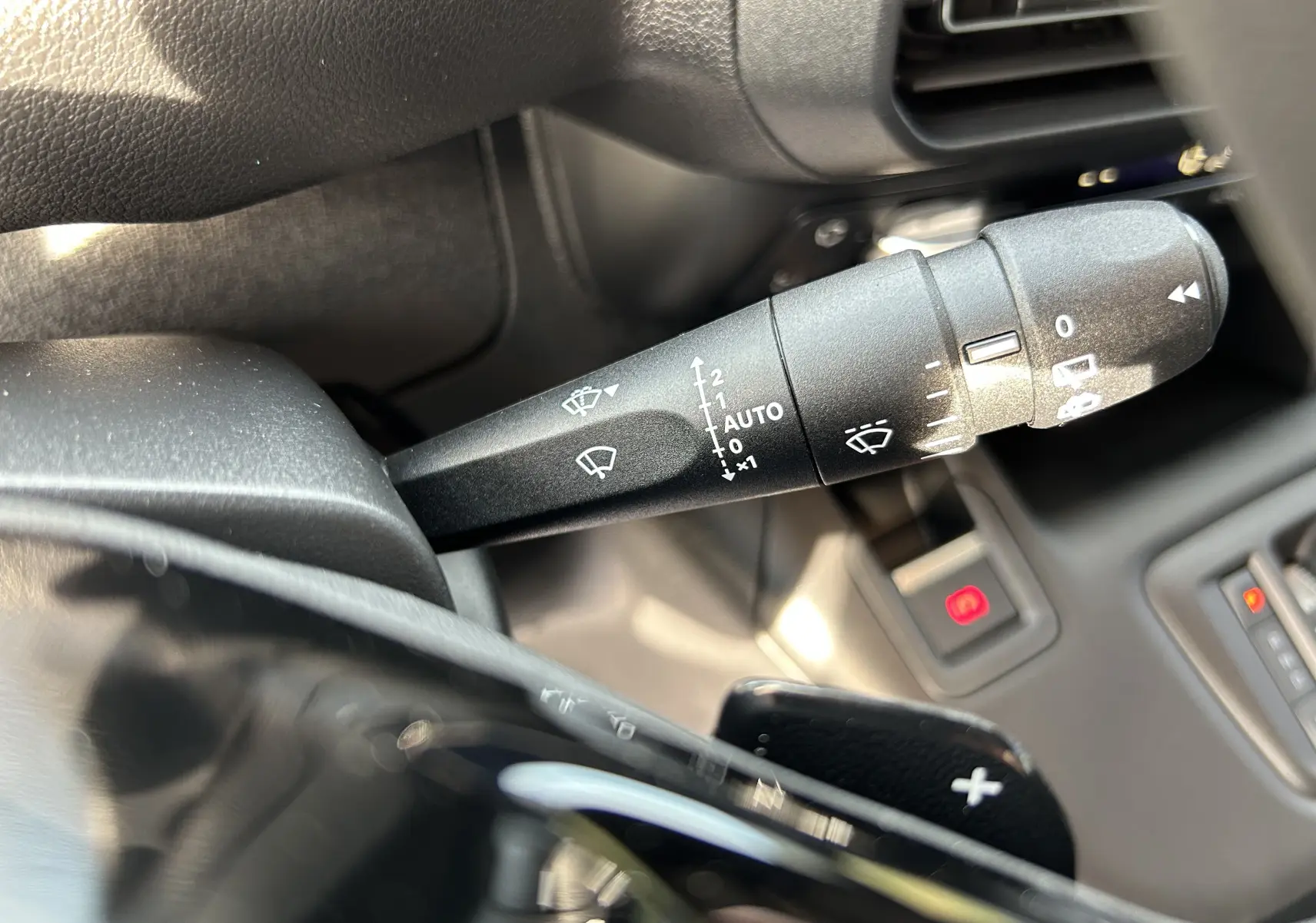 Gros plan sur la commande d'essuie-glace et la palette de changement de vitesse dans l'habitacle du Peugeot Partner Fourgon blanc.