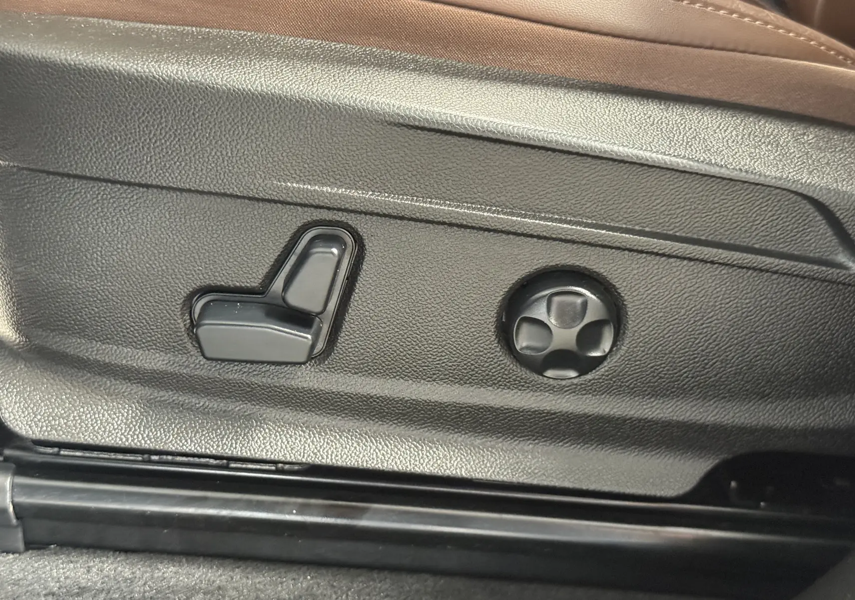 Gros plan sur les commandes de réglage électrique du siège côté conducteur de l'Alfa Romeo Stelvio gris Lusso 2017.