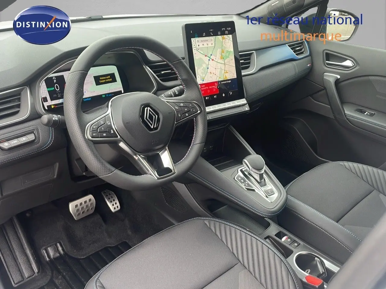 Intérieur avant droit du Renault Captur E-Tech hybride 2025, tableau de bord moderne avec écran tactile vertical et volant multifonction.