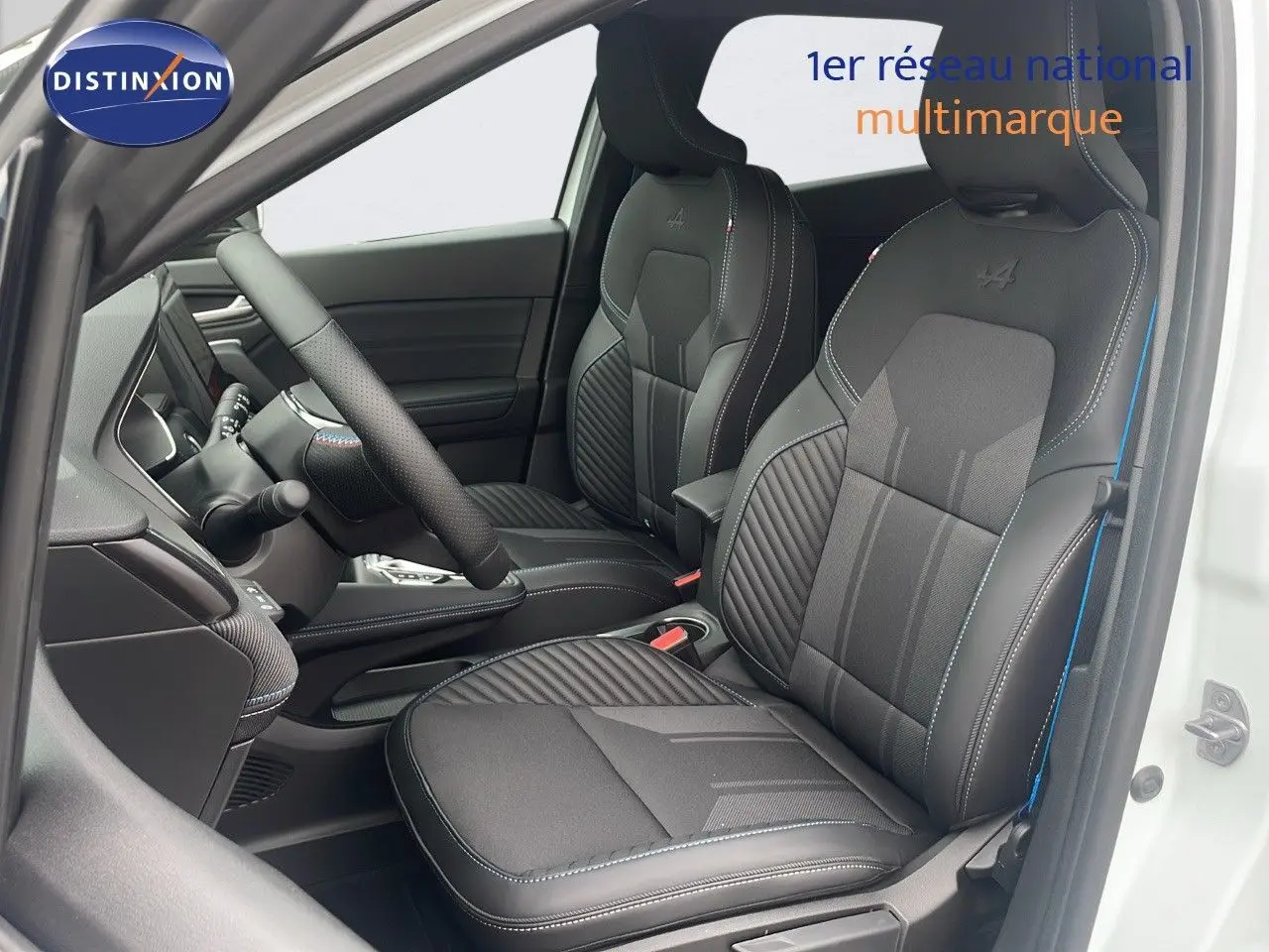 Intérieur avant du Renault Captur E-Tech hybride 2025 avec sièges noirs en cuir et surpiqûres bleues, porte blanche ouverte.