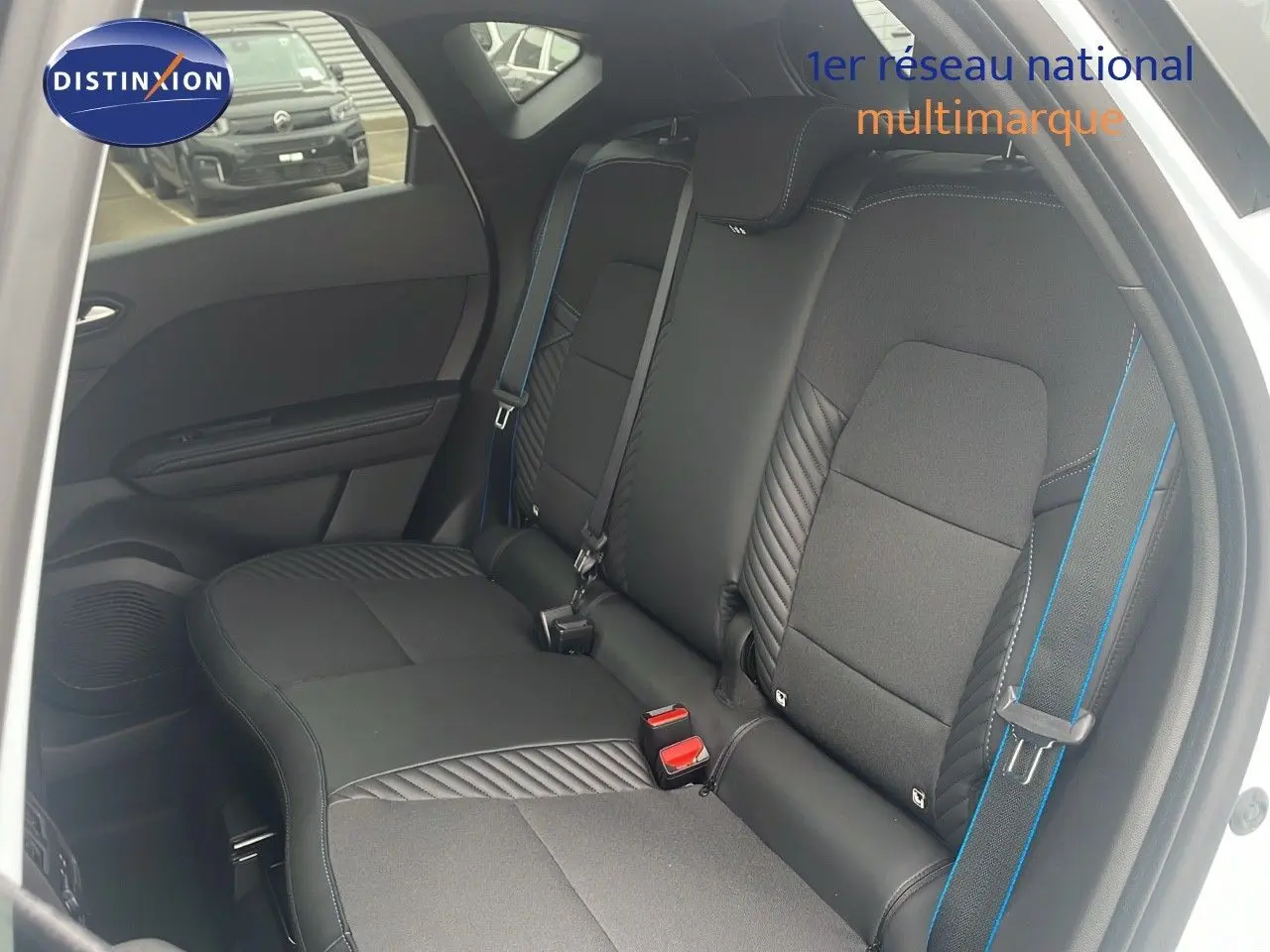 Vue intérieure côté droit sur la banquette arrière en cuir noir avec surpiqûres bleues du Renault Captur blanc nacré 2025.