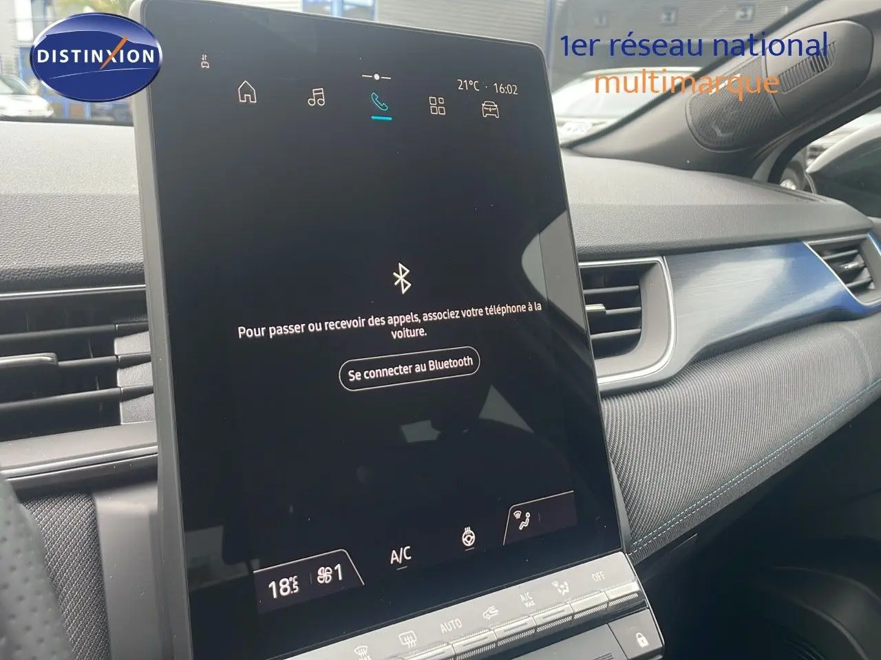 Écran tactile central du tableau de bord du Renault Captur E-Tech blanc nacré, avec détails intérieurs modernes et finition noire.