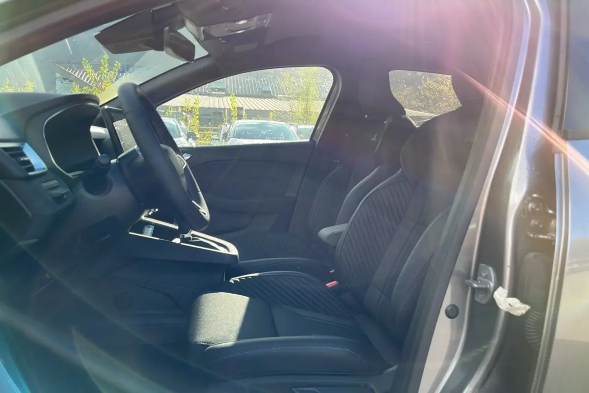 Vue intérieure côté gauche de la Renault Clio V E-Tech 145 Esprit Alpine Bose avec sièges sport noirs et volant cuir.