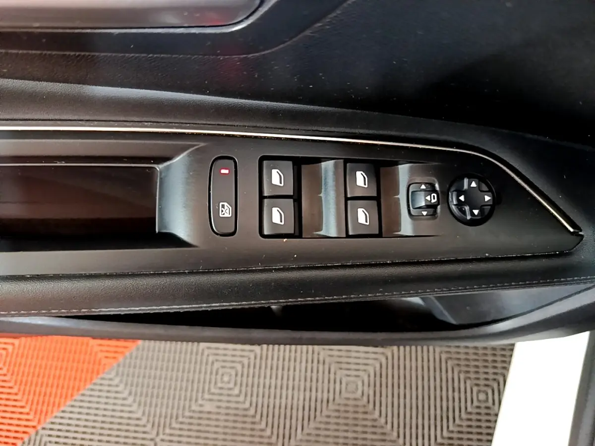Gros plan sur les commandes des vitres et rétroviseurs côté gauche intérieur d’un Peugeot 3008 blanc hybride rechargeable.