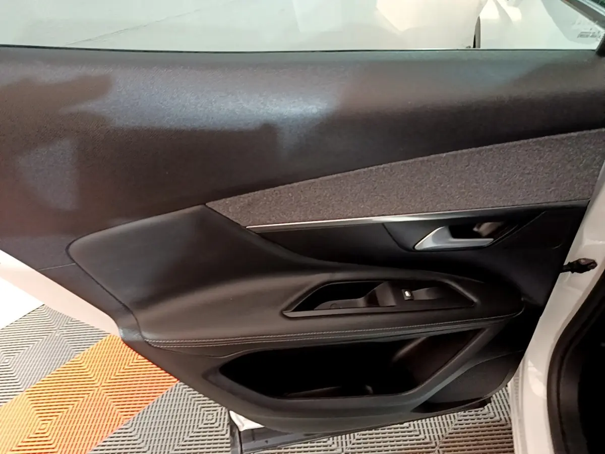 Gros plan sur la porte avant droite noire du Peugeot 3008 blanc, mettant en valeur les commandes de vitre et la poignée.