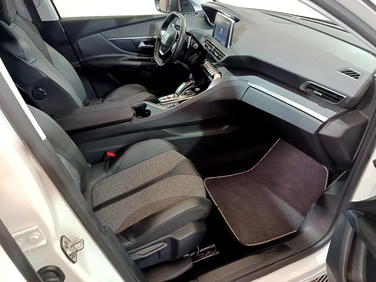 Vue intérieure côté passager avant du Peugeot 3008 blanc, avec sièges bi-matière et tableau de bord moderne.