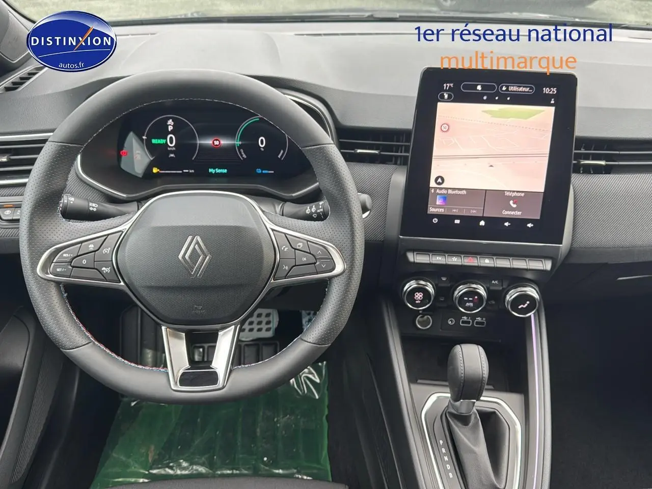 Vue intérieure avant de la Renault Clio V 1.6 e-tech avec volant multifonction et écran tactile central lumineux