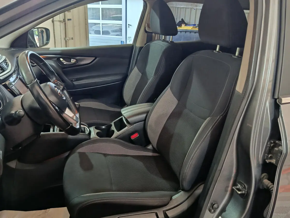 Intérieur du Nissan Qashqai 2019 gris clair, vue côté conducteur montrant sièges noirs et volant cuir multifonctions.