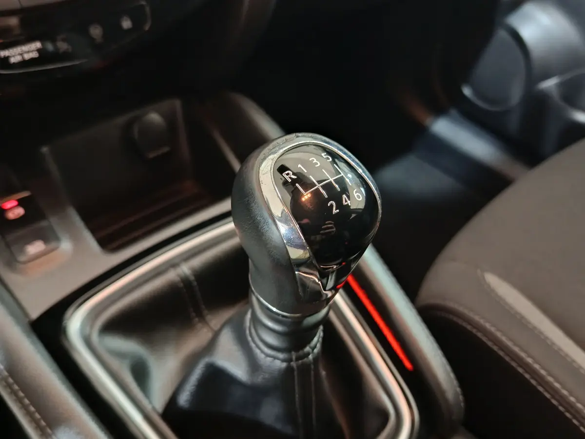 Le levier de vitesses manuel noir du Nissan Qashqai 1.5 DCI 115 Business Edition vu en gros plan intérieur.