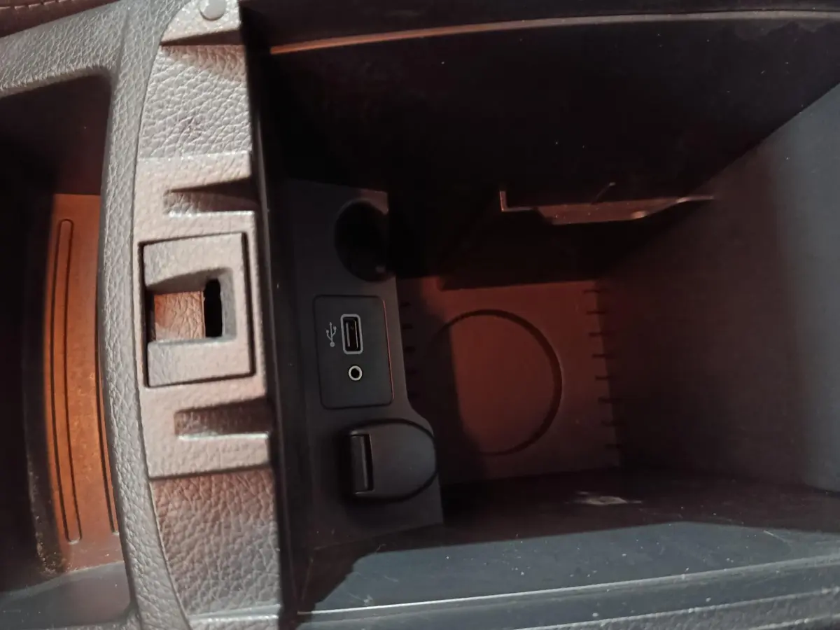 Vue rapprochée de la console centrale du Nissan Qashqai gris clair, montrant prise USB et prise jack audio.