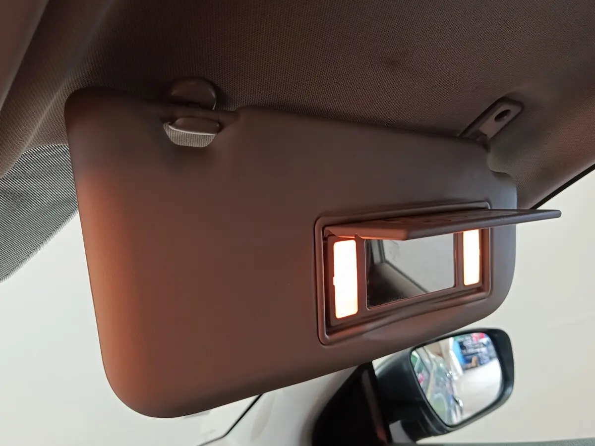 Miroir de courtoisie éclairé sur pare-soleil côté conducteur dans l'habitacle d'un Nissan Qashqai gris clair 2019.
