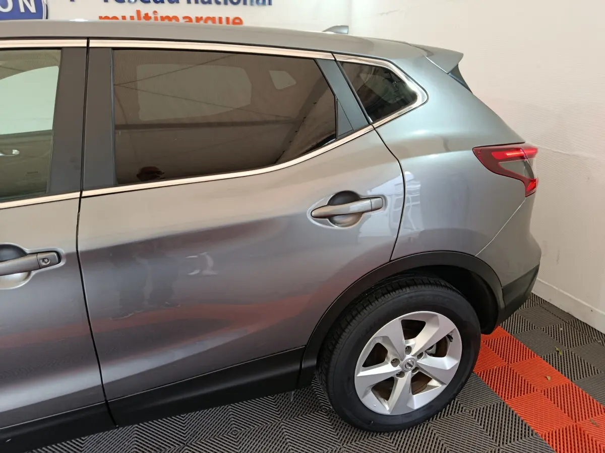 Vue latérale côté droit du Nissan Qashqai gris clair 2019, mettant en valeur la porte arrière et la roue arrière.