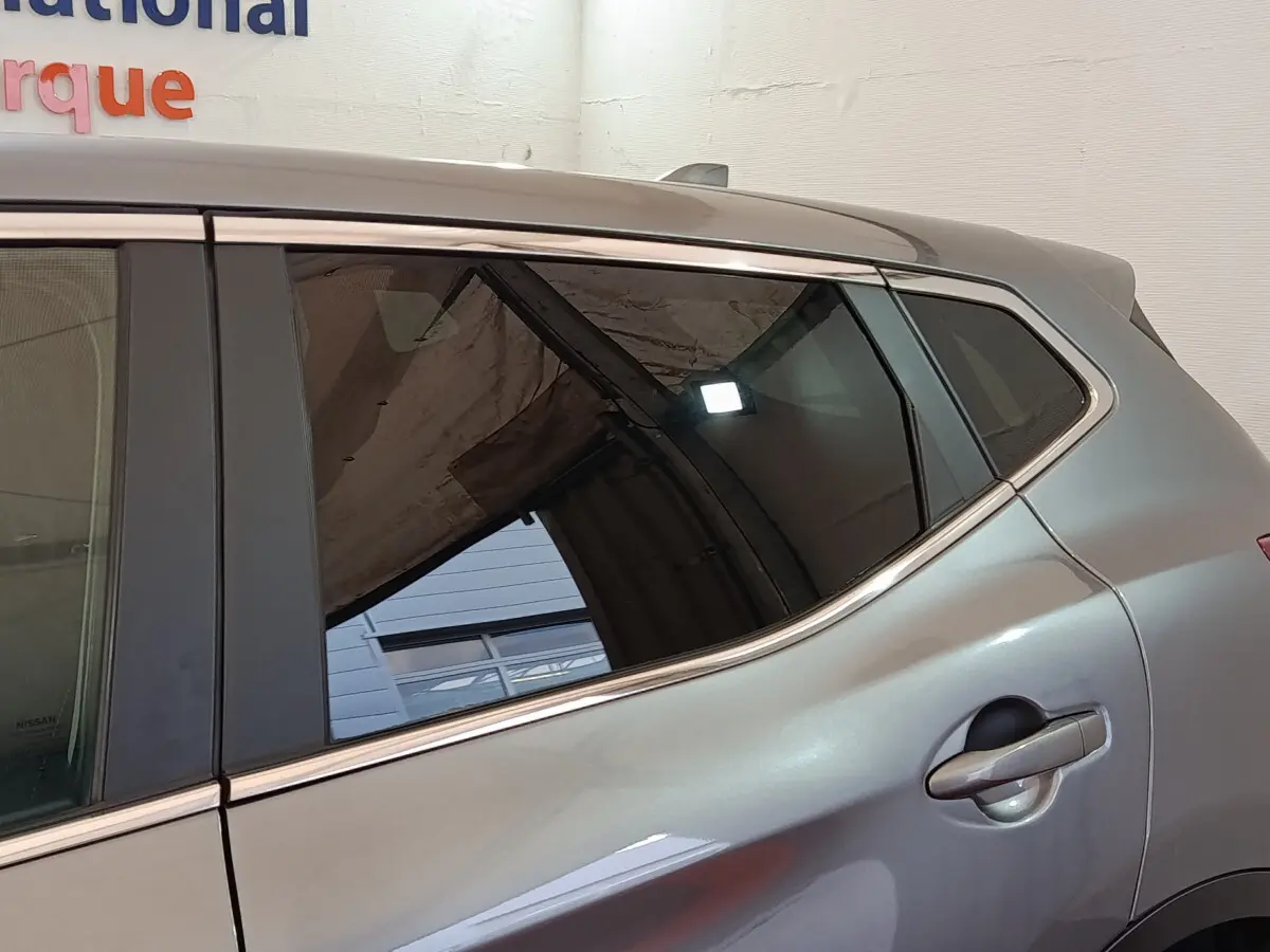 Vue latérale côté droit sur la porte arrière gris clair du Nissan Qashqai 1.5 DCI 115 Business Edition 2019 avec poignée intégrée.