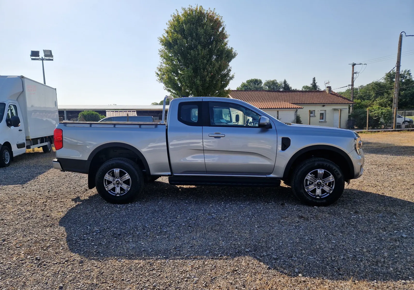 Ford Ranger Super Cabine gris Iconic vu de profil côté gauche, avec roues tout-terrain et arceau arrière.