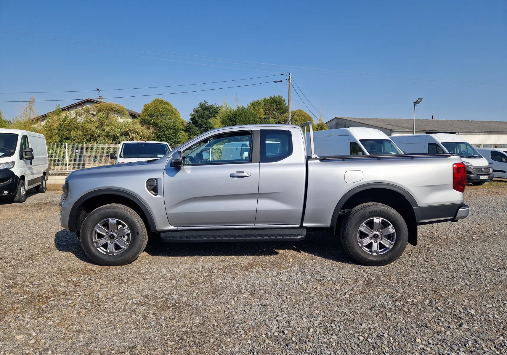 Vue 3/4 arrière droite du Ford Ranger Super Cabine gris Iconic avec attelage et barres de protection sur la benne.