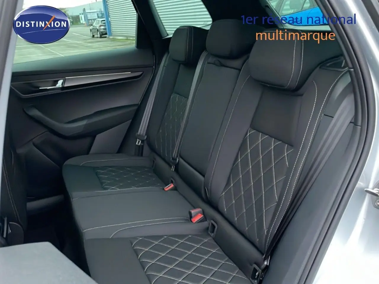 Vue intérieure sur les sièges arrière en tissu noir avec surpiqûres blanches du Skoda Karoq gris argent 2025.