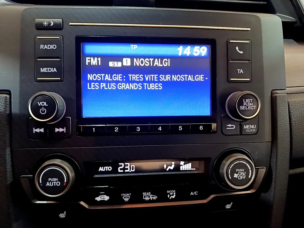 Vue rapprochée du tableau de bord de la Honda Civic 1.0 i-VTEC Exclusive 2020, écran tactile et commandes climatisation visibles.