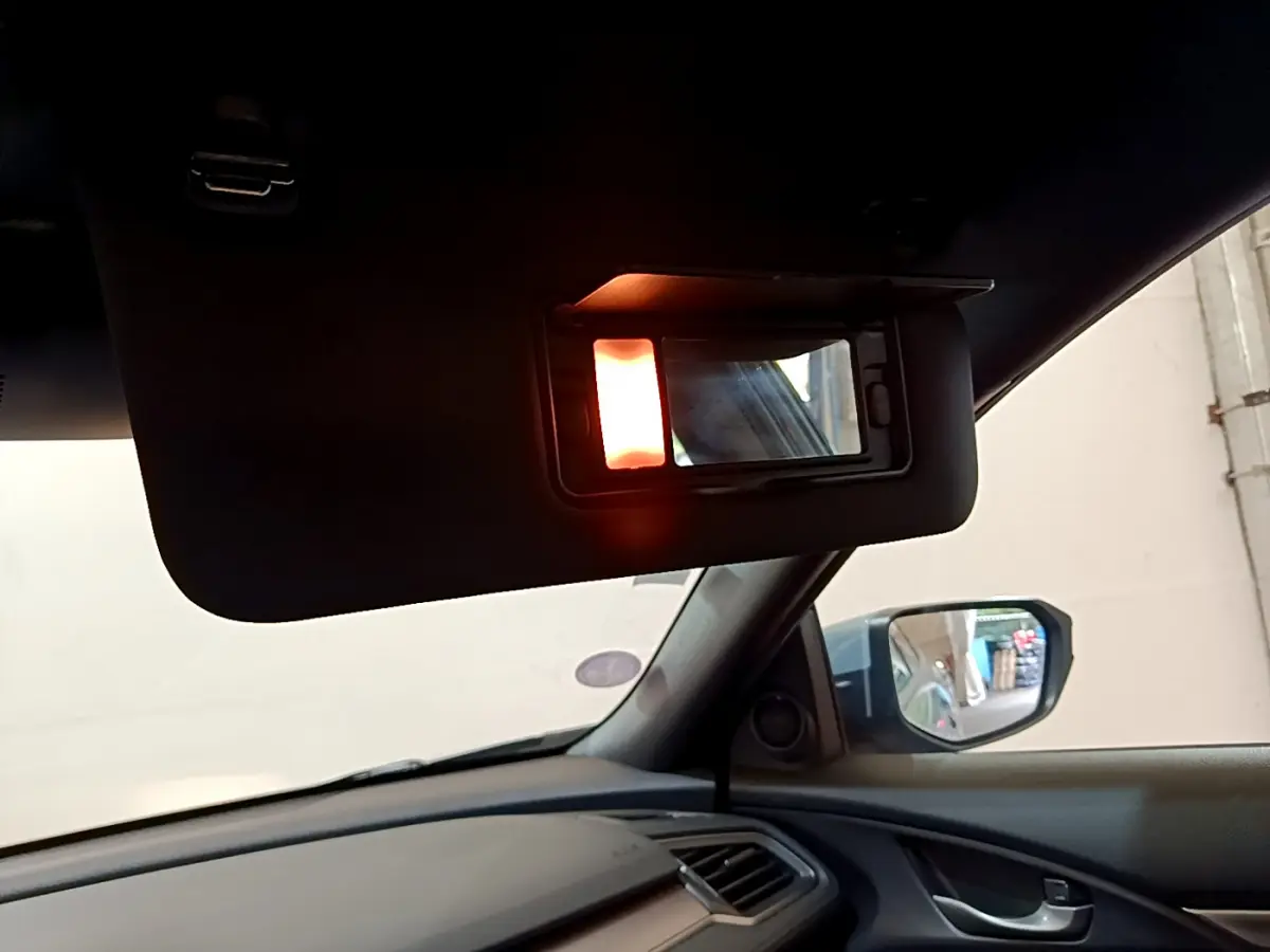 Vue intérieure du pare-soleil côté conducteur avec miroir éclairé dans une Honda Civic gris foncé de 2020.