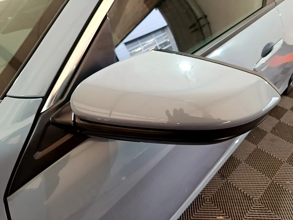 Gros plan sur le rétroviseur droit gris clair de la Honda Civic 1.0 i-VTEC Exclusive 2020, avec reflet lumineux.