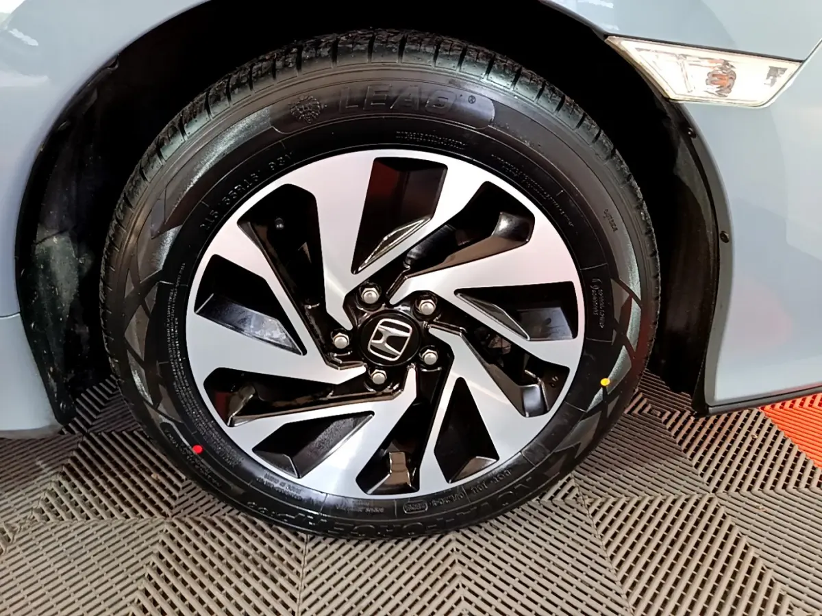 Gros plan sur la roue avant droite de la Honda Civic 1.0 i-VTEC Exclusive gris foncé avec jante alliage bicolore.