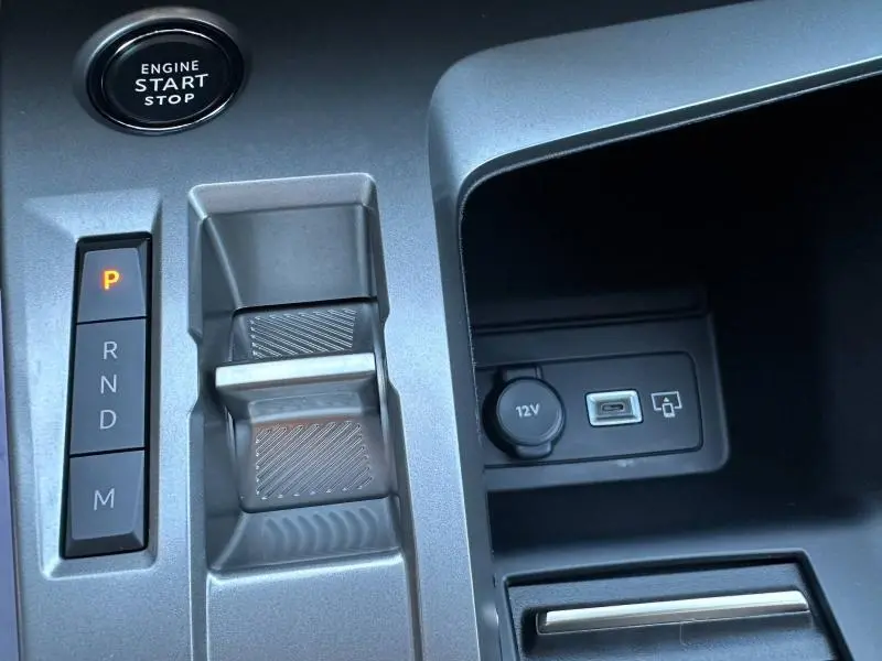 Gros plan sur la console centrale de la Peugeot 308 SW 2024, montrant la commande de boîte auto et prise USB avec bouton start/stop.