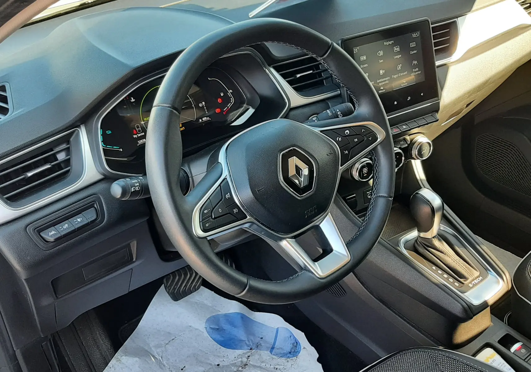 Vue intérieure du poste de conduite du Renault Captur E-Tech 145ch Intens 2022, volant multifonction et écran tactile central.
