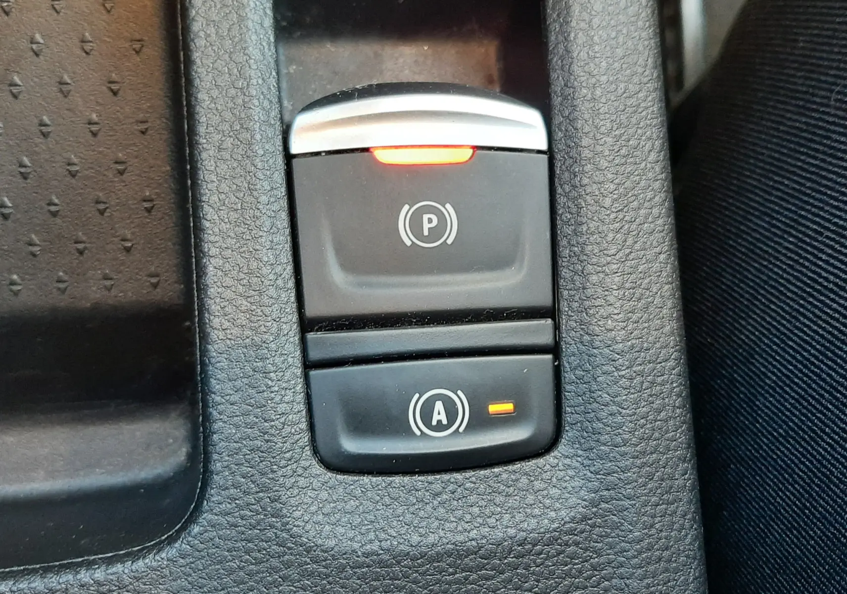 Gros plan sur les commandes de frein à main électrique et d’aide au démarrage sur Renault Captur E-Tech blanc nacré.