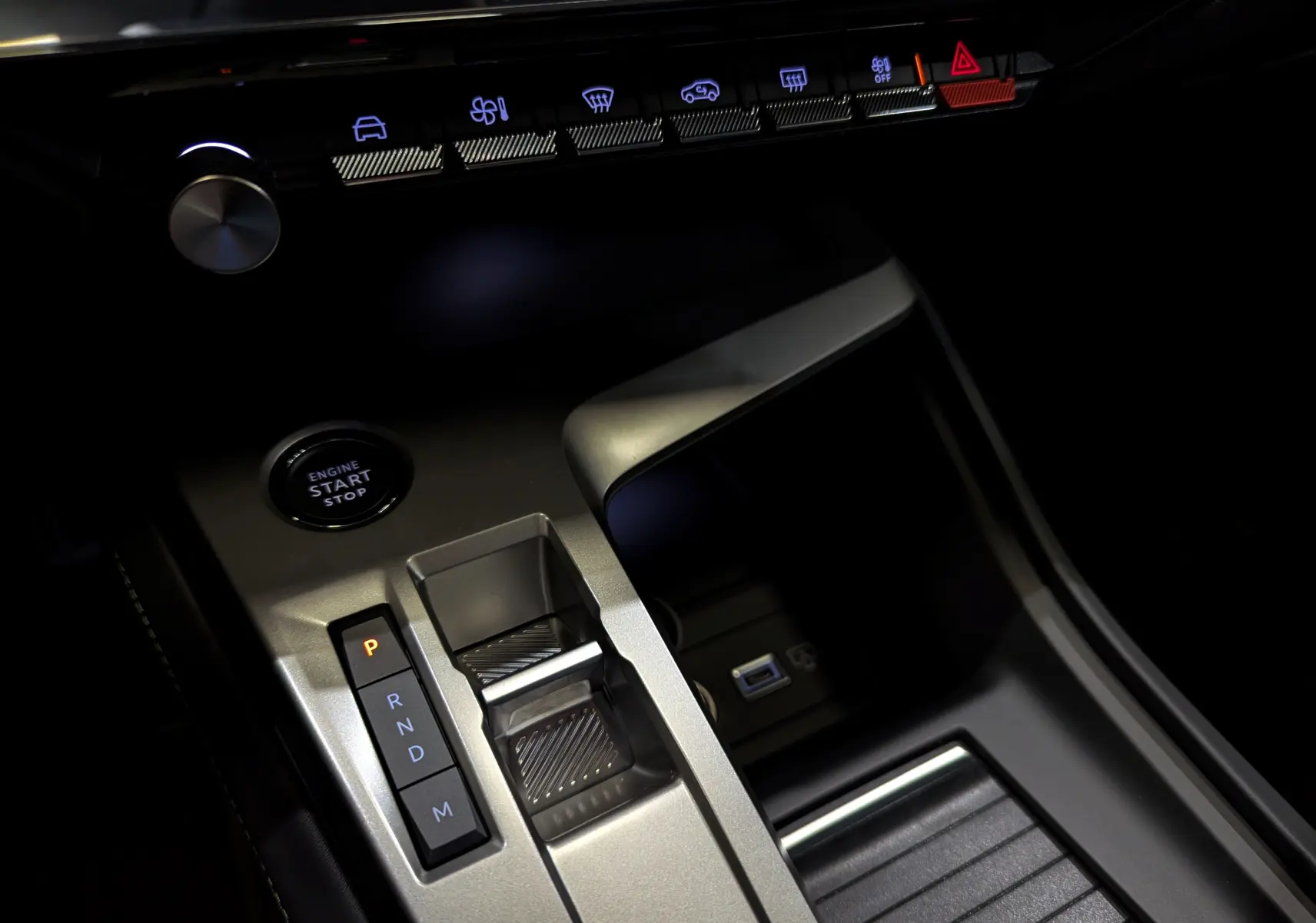 Gros plan sur la console centrale de la Peugeot 308 GT 2025, avec levier de vitesses automatique et bouton start/stop.