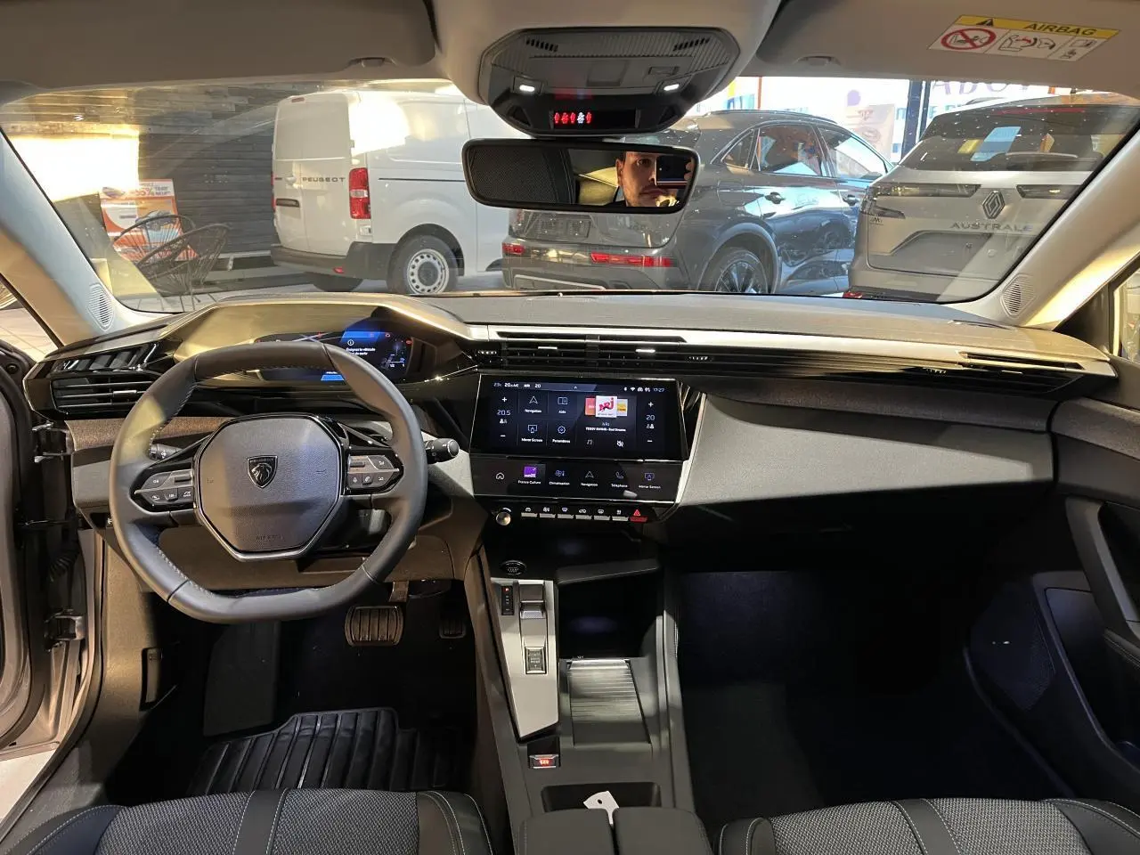 Intérieur avant d'une Peugeot 308 SW 2024 gris clair Metal Artense, tableau de bord moderne avec écran tactile central.