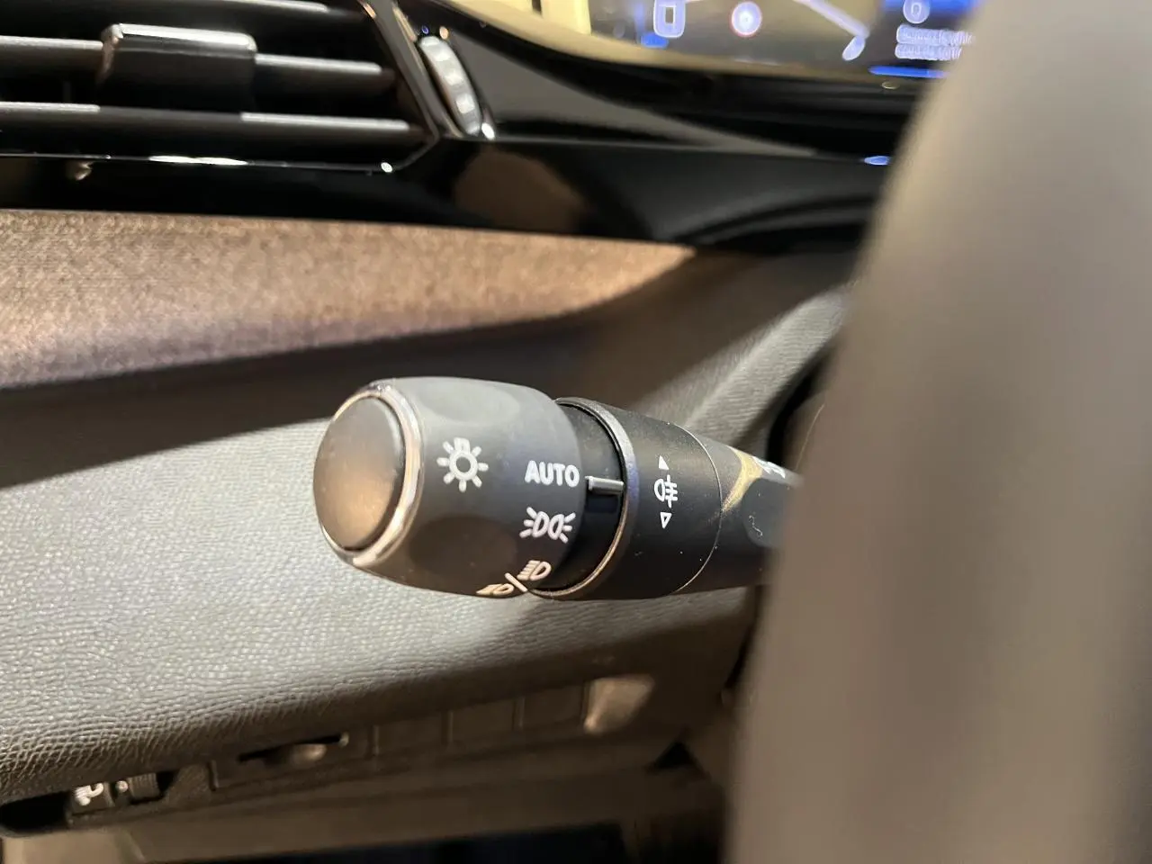 Gros plan sur la commande d'éclairage à gauche du volant du Peugeot 308 SW gris clair Metal Artense 2024.